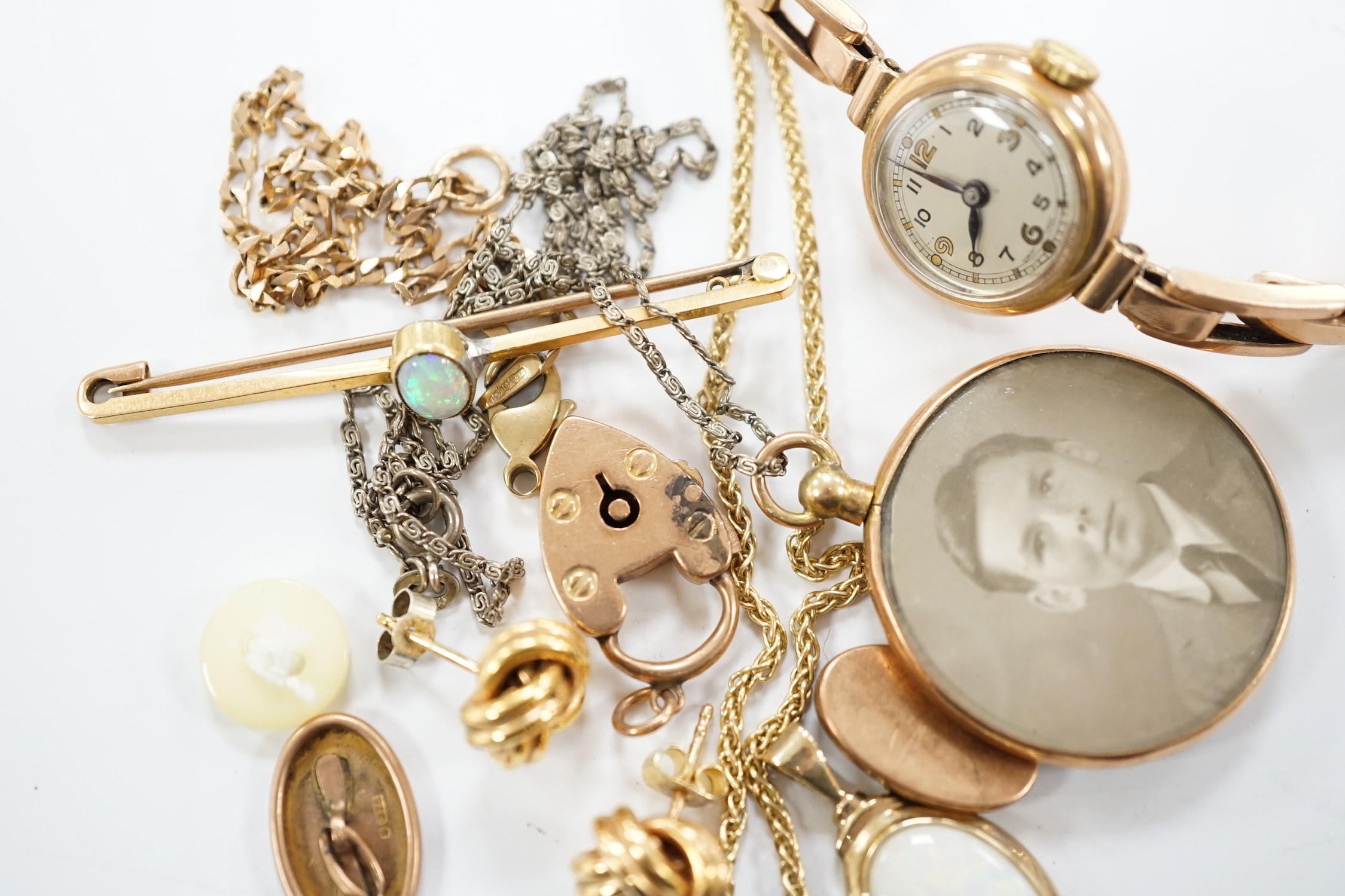 A lady's yellow metal manual wind wrist watch, on a 9ct expanding bracelet, a modern 9ct gold and white opal set pendant, on a 375 chain and other minor jewellery including a pair of 9ct gold knot earrings.